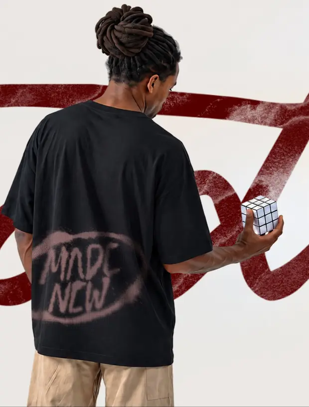 Costas da camiseta Made New em um modelo segurando um cubo mágico