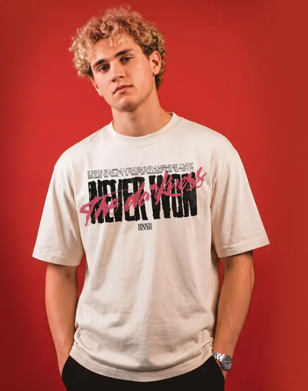 Modelo de cabelo cacheado loiro em fundo vermelho vestindo a camiseta Never Won